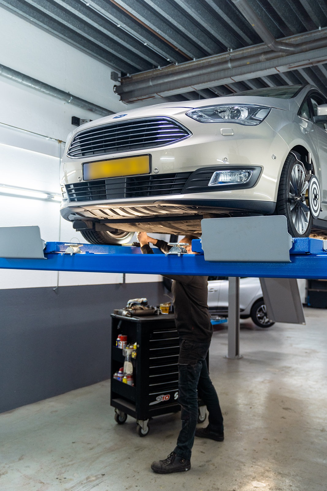 De auto wordt uitgelijnd door een monteur van autobedrijf De Loods Nieuwegein